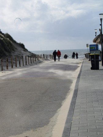 Un chemin venteux qui menait vers la plage, aux Pays Bas. On voit dans le ciel la voile d'un kite surf et au premier plan le sable très fin "flouté" par le mouvement que le vent lui donnait.