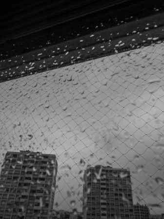 Des gouttes de pluie sur ma fenêtre, sur fond de ciel sombre.
