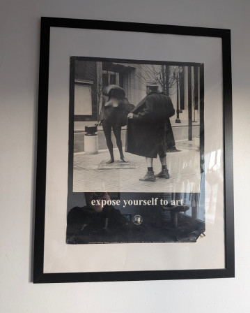 Une photo qui se trouve dans mon salon : un exhibitionniste de trois quart dos ouvre grand son manteau devant une statue. La légende dit : expose yourself to art.