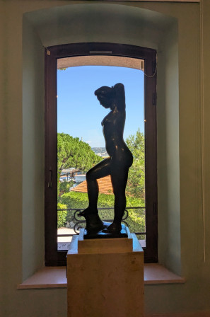 Une statue représentant une femme nu, debout, de profil devant une fenêtre qui donne sur le port de Saint Tropez (Musée de l'Annonciade)