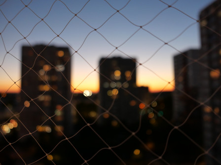 Des tours floues derrière un filet net, à la lueur du soleil couchant.