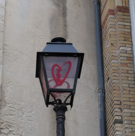 Un lampadaire ancien dont les vitres sont taguées d'un coeur brisé.