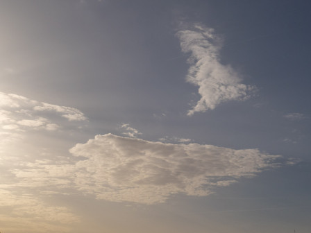 Un nuage dans la lumière du matin, sur fond de ciel bleu et de dorures.