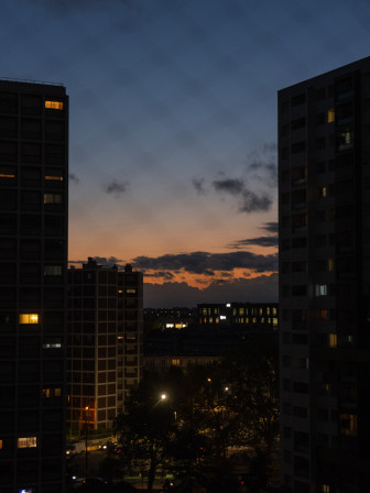 Des yeux orange et jaunes, fenêtres allumées dans la nuit qui tombe.
