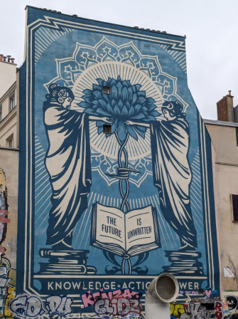 Une façade d'immeuble peinte d'un graph / fresque dont le message est : the future is unwritten.