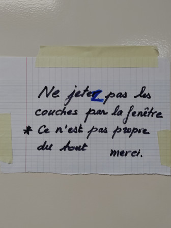 Un panneau sur mon ascenseur qui dit "Ne jeter (corrigé en jetez à coup de marqueur rageur) pas les couches par la fenêtre, ce n'est pas propre du tout. Merci".